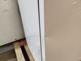 a white refrigerator sitting on a pallet in a warehouse