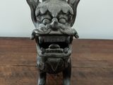 a small statue of a dragon sitting on a wooden table