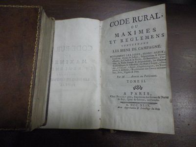 un livre ouvert posé sur une table, à côté d'une table en bois