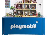 une vitrine Playmobil bleue contenant une maison de poupées