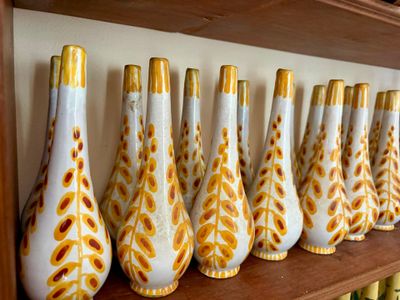 de nombreux vases alignés sur une étagère dans une pièce
