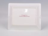 an empty white square plate with a red inscription on it