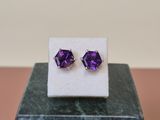 une paire de boucles d'oreilles en améthorate posées sur un bloc de marbre