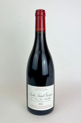 la bouteille de vin rouge est posée sur une surface blanche