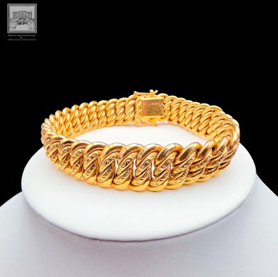 an image of a gold bracelet on a mannequin