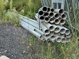 un tas de tuyaux posé par terre près d'une clôture