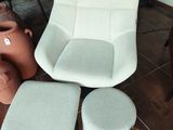 un fauteuil, un pouf et un autre pouf dans un salon