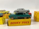 several toy cars are sitting on top of boxes on a white surface