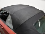a red car with a black top parked in a garage