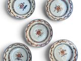 six petites assiettes ornées de motifs floraux sont disposées sur une surface blanche