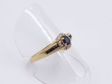a close up of a gold ring with a sapphire stone
