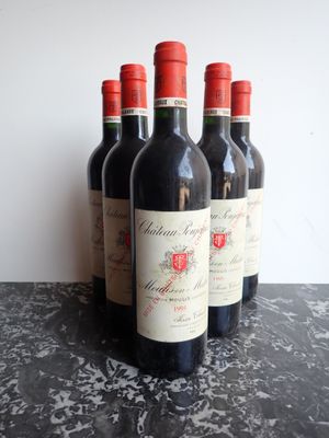 quatre bouteilles de vin rouge sont alignées sur une table