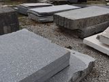 a pile of granite blocks on the ground in a cemetery