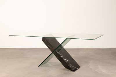 une table en verre avec un piètement en marbre noir et blanc