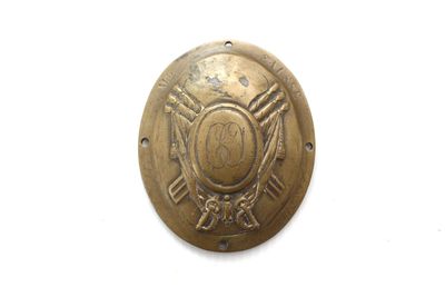 une vieille plaque en laiton sur laquelle figure l'emblème des pompiers