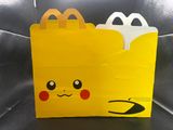 a close up of a yellow bag with a face on it