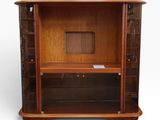 a wooden entertainment center with a glass door and shelves