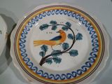 une assiette avec un oiseau dessus et un bol avec un oiseau dessus