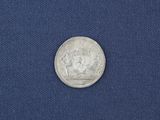 a close up of a silver coin on a blue cloth