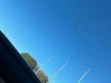 the view from inside of a car looking up at a plane flying in the sky