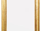 a gold framed mirror on a white wall with a white background