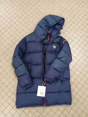 a close up of a blue down jacket on a tiled floor