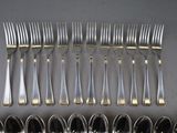 a lot of forks and spoons that are on the table