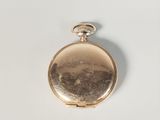 an old pocket watch sitting on top of a white surface