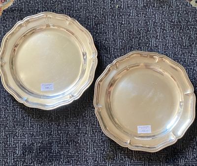 two silver plates sitting on a blue carpet next to each other