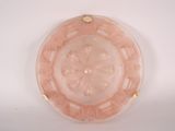 a pink glass bowl with a gold rim on a white surface