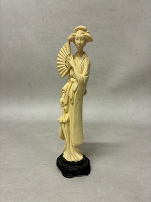 ivory figurine of a woman holding a fan and a fan