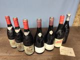several bottles of wine are lined up on a wooden table