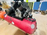 a red air compressor sitting on top of a red tank