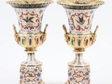 une paire de vases posés l'un sur l'autre sur une surface blanche