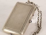 a silver purse with a chain around it on a table