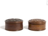 pair of wooden boxes with carvings on top of them on a white surface