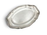 an oval silver plate with a scallop edge on a white surface