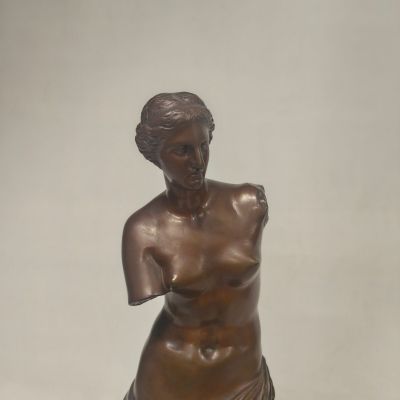 bronze statue of a woman sitting on a marble base