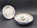 deux assiettes ornées d'oiseaux et de fleurs sur un fond noir