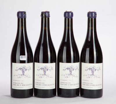 three bottles of wine are lined up on a white surface
