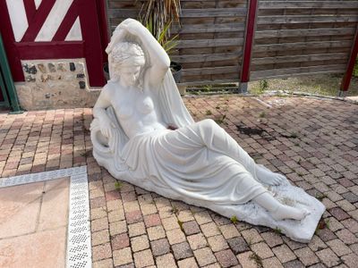 a statue of a woman laying on the ground