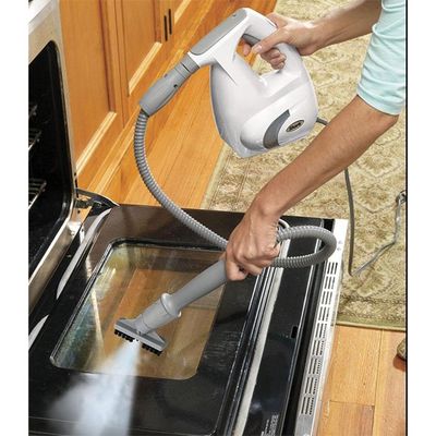 a person using a steam cleaner to clean an oven