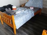 un lit avec une couette bleue et une tête de lit en bois