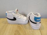 white and black nike sneakers with blue accents on a wooden table