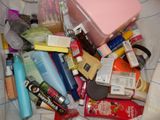 a pile of cosmetics and other items on a bed