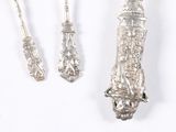 three silver spoons and a fork on a white surface