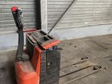 a fork lifter in a warehouse with a door in the background