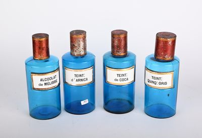 trois bouteilles bleues, munies d'étiquettes, posées les unes à côté des autres