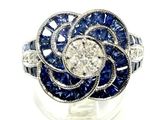 an image of a diamond and sapphire flower ring on a clear surface