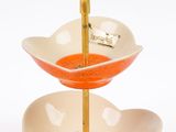 a three tiered serving dish with a spoon in it